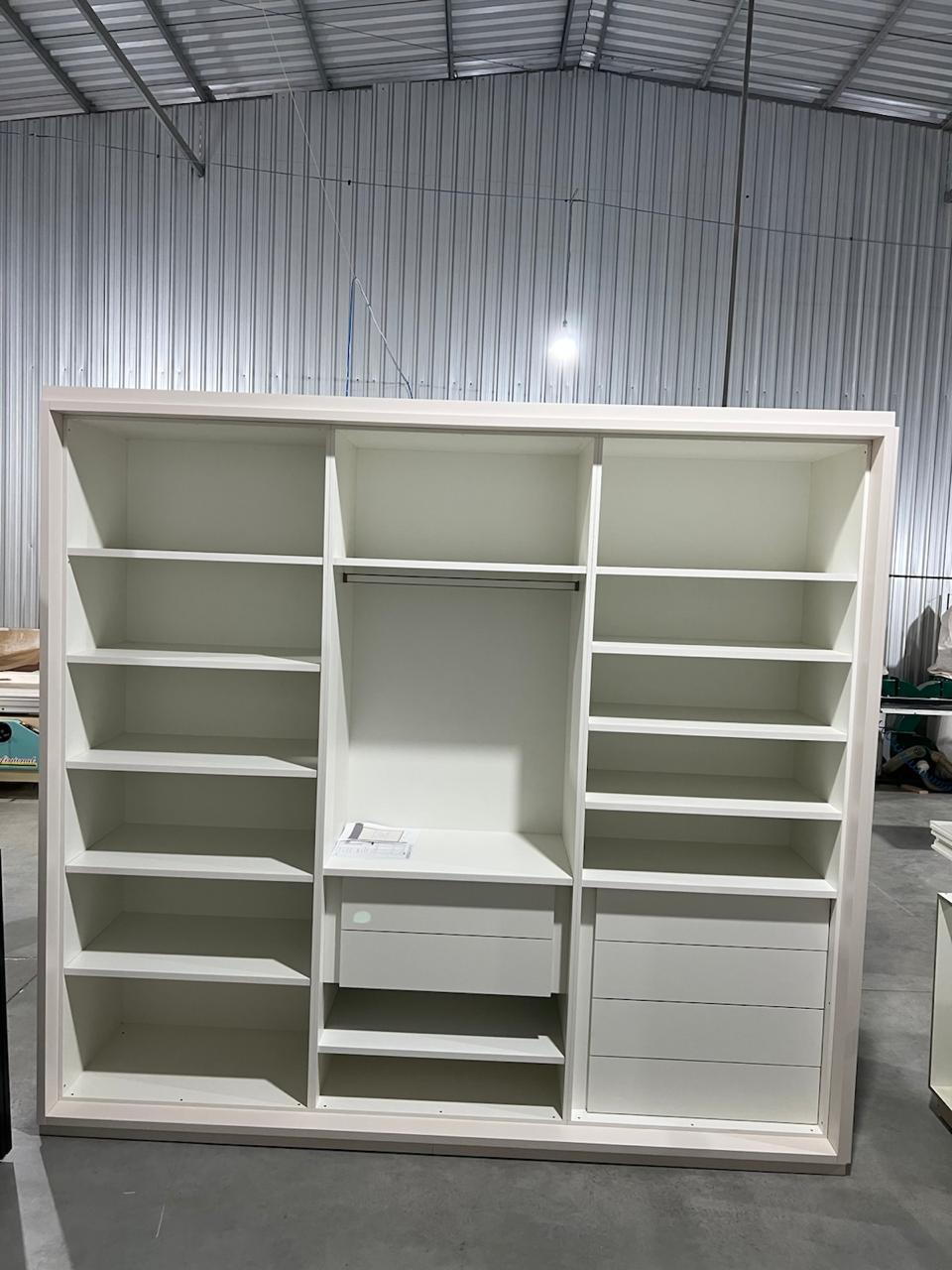 Closet branco sob medida com nichos, cabideiro e gavetas