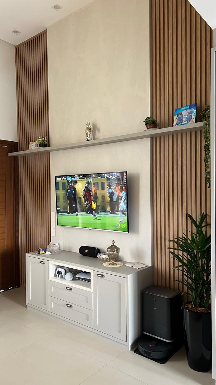 Sala com painel ripado, prateleira e rack planejado
