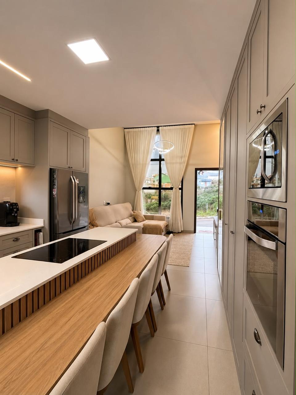 Cozinha gourmet integrada com bancada em madeira